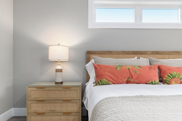 Une chambre à coucher bien rangée, avec un lit, une lampe de chevet et une table de nuit.