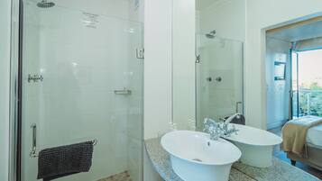 A modern bathroom with a glass-enclosed shower, a double sink vanity, and a large mirror.