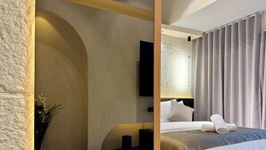 Ein modernes Hotelzimmer mit einem großen Bett, einem Flachbildfernseher und einer Topfpflanze.