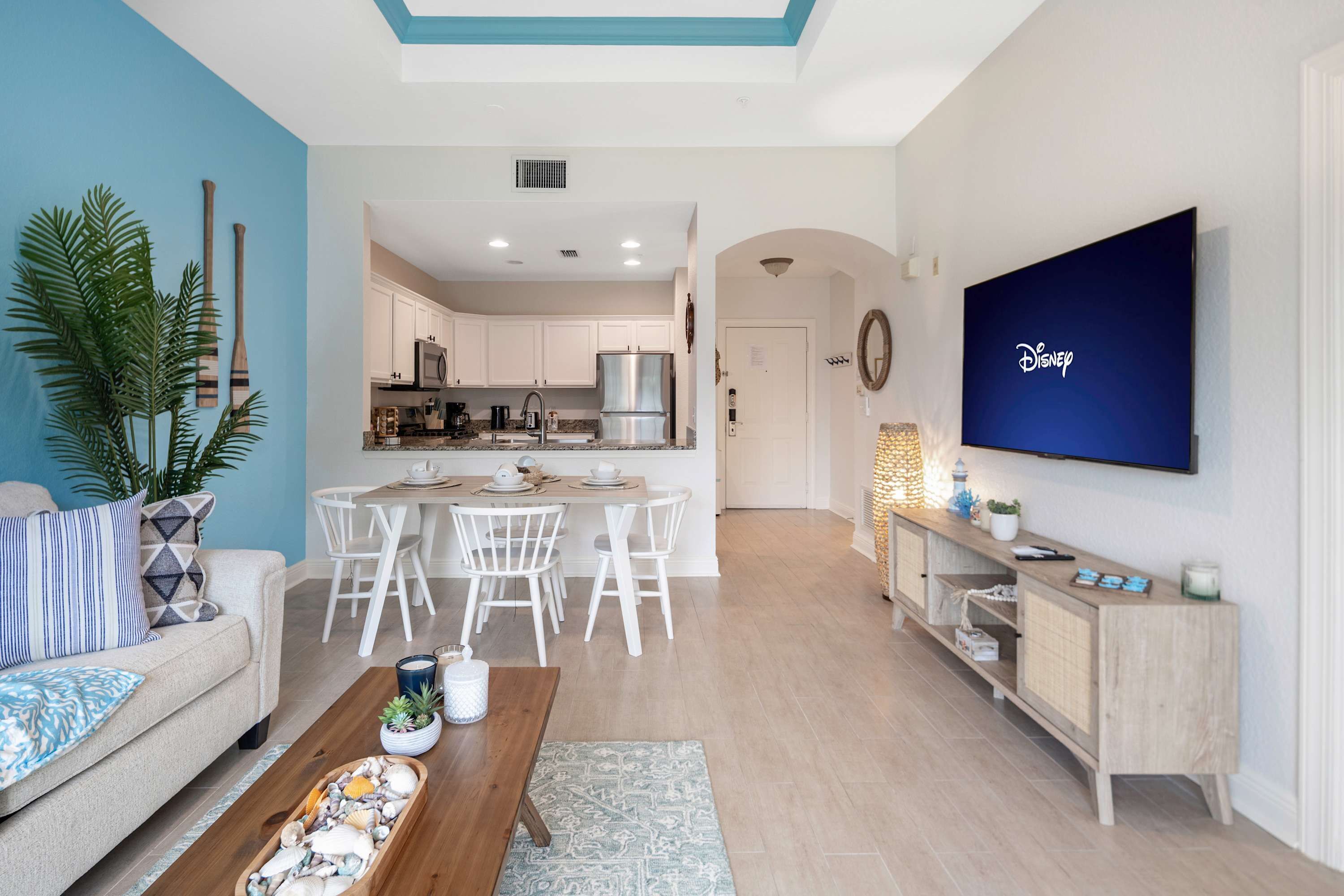 A modern living room with a sofa, coffee table, and a TV mounted on the wall.