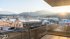A view of a building with a metal roof, a sign that reads "DANCE STUDIO," and a parking lot with several cars. - MoHost Urban Plaza (Brasov)