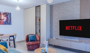 Lägenhet Deluxe - 1 sovrum - balkong - utsikt mot bergen | Vardagsrum | 125-centimeters smart-tv med kabelkanaler, Netflix och streamingtjänster