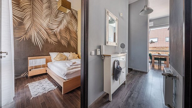 Un dormitorio moderno con una cama grande, una mesita de noche, un armario y un baño con ducha.
