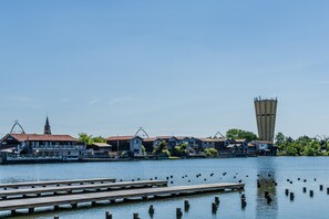 Une propriété située au bord de l’eau, dotée d’un quai, d’une haute tour et d’une rangée de maisons surmontées d’un clocher d’église.