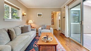 A living room with a sofa, a coffee table, a lamp, and a ceiling fan. - Private Hot Tub - Riverfront Cabin In Estes Park! (Estes Park)