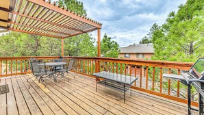 A wooden deck with outdoor furniture, including a table and chairs, and a grill. - 4 Mi to Dtwn: Cozy Family Condo in Ruidoso! (Ruidoso)