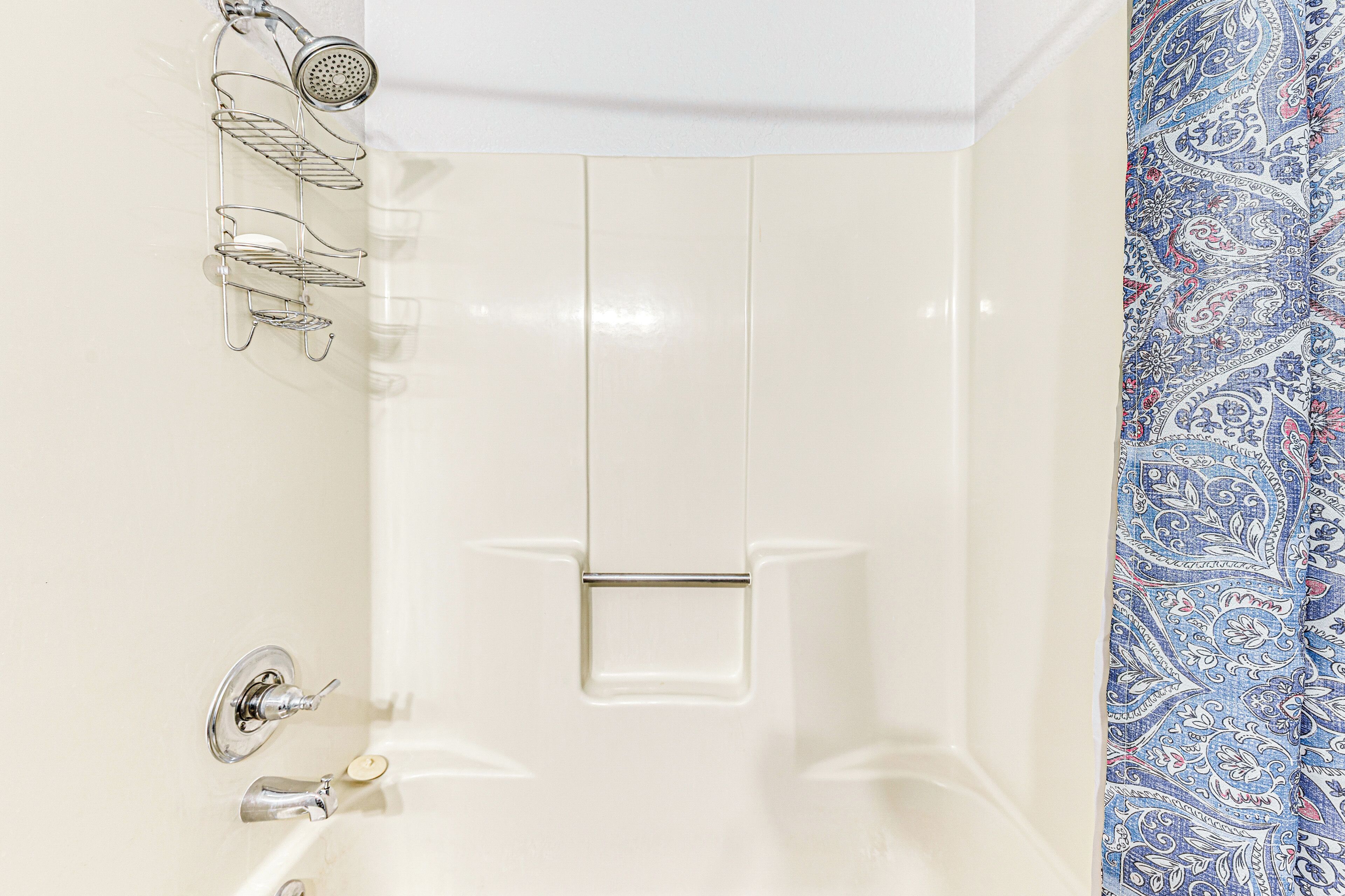 Un baño con ducha, perchero y un inodoro.