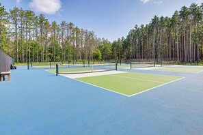 A tennis court with a net, surrounded by a fence and trees. - Sand Valley Golf Home w/ Association Pool (Nekoosa)