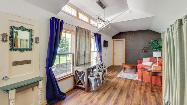 A spacious living area with a dining table, chairs, a sofa, and a TV. - 5 Mi to Lake Ouachita: Peaceful Cabin Retreat (Royal)
