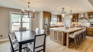 Una cocina amplia con una isla grande, armarios de madera y electrodomésticos modernos.