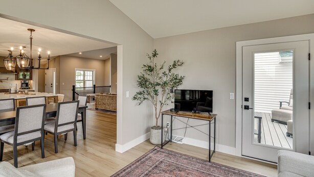 A modern living room with a dining area, a TV on a stand, and a large window. - Walk to Beaches + Restaurants: Elkhart Lake Escape (Elkhart Lake)