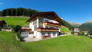 A two-story building with balconies, surrounded by green fields and mountains. - Apartment 'Tscharfhof' with Mountain View and Private Terrace (San Leonardo in Passiria)