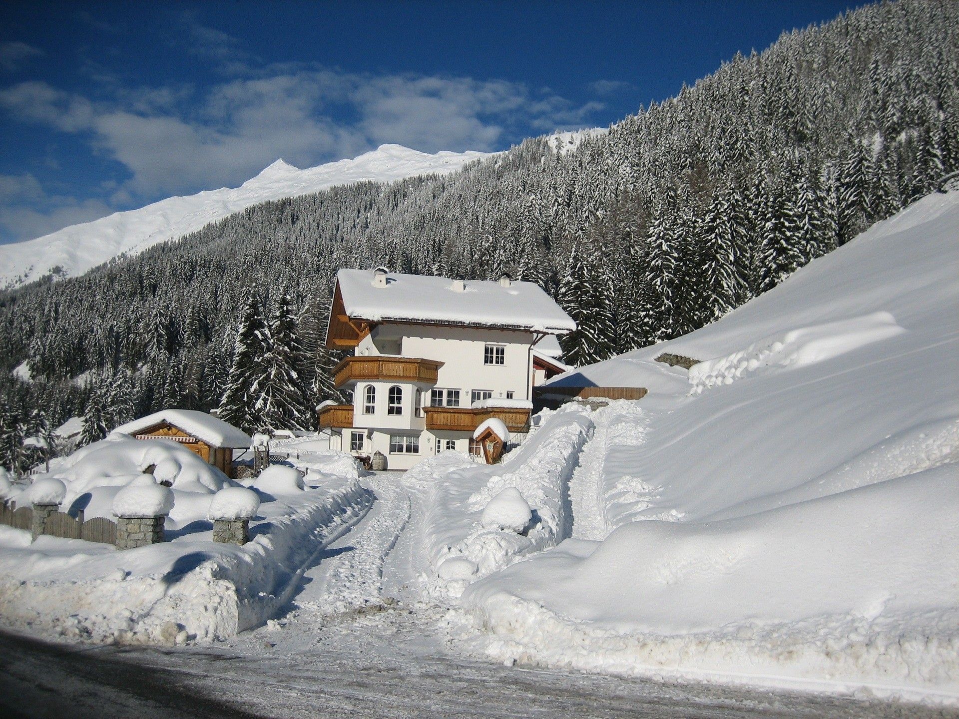 Un albergue en la montaña cubierto de nieve con cielo despejado.
