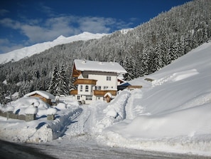 Een met sneeuw bedekte berglodge onder een heldere lucht.