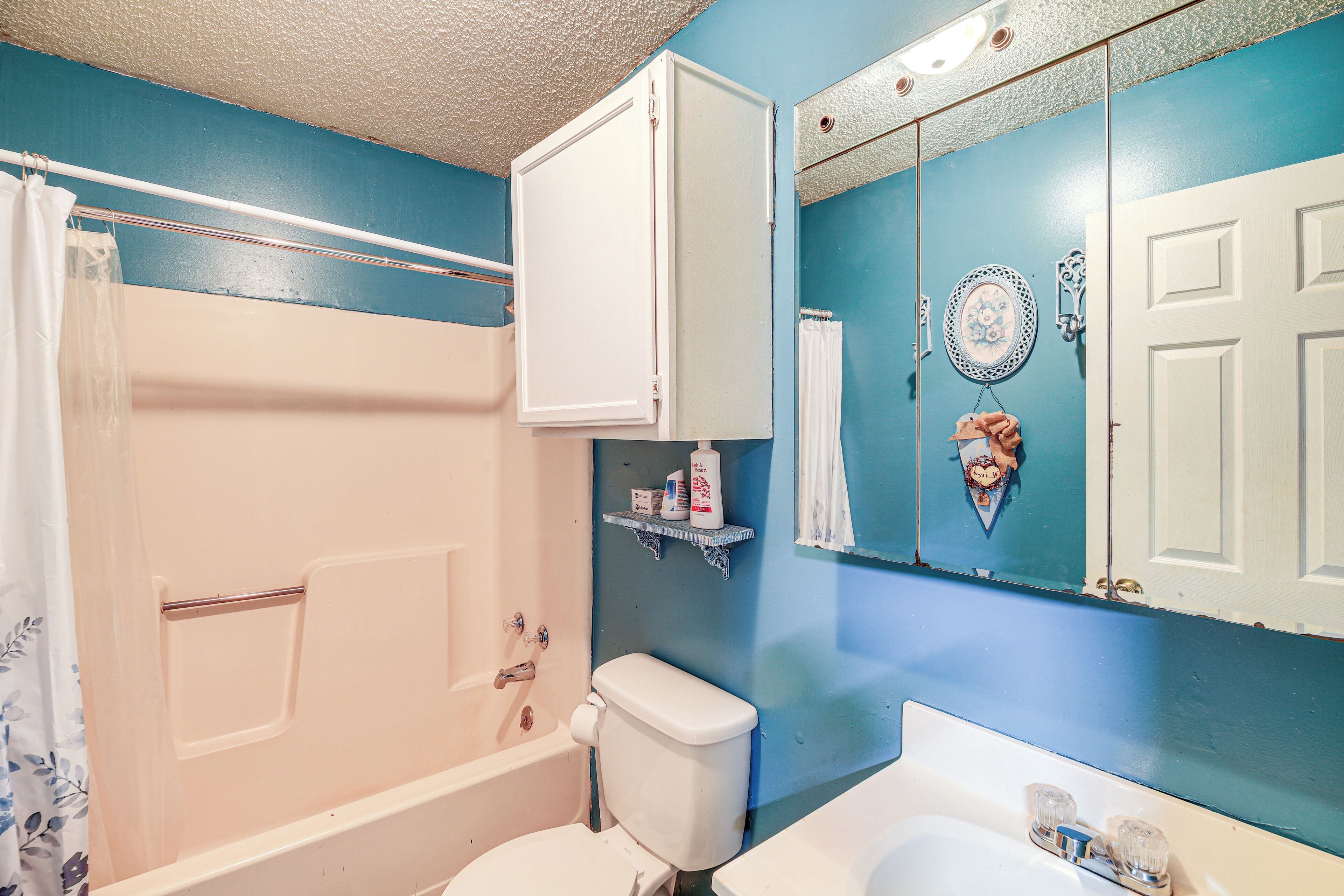 A bathroom with a bathtub, toilet, and sink.