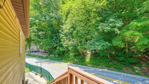 A yellow building with a wooden deck overlooking a road with a guardrail and greenery. - 1 Mi to Hatfield-mccoy Trails: Apt in Matewan (North Matewan)