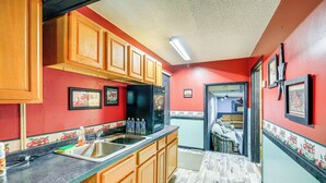 A kitchen with wooden cabinets, a black refrigerator, and a sink. - 1 Mi to Hatfield-mccoy Trails: Apt in Matewan (North Matewan)