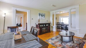 A dining area with a wooden table, chairs, a buffet cabinet, and a round coffee table. - Renovated 1800s Brick Farmhouse in Granville (Granville)