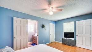 A bedroom with a bed, a dresser, a television, and a ceiling fan. - Hike, Fish & Ride: Pet-friendly Huntsville Home (Huntsville)