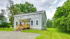 A two-story house with a front porch, a wooden staircase, and a gravel driveway. - Mountain & Sunset Views: Upstate Family Home (Granville)