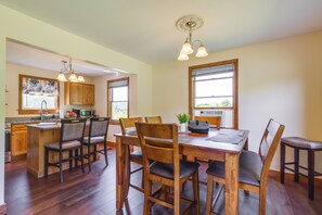 A spacious kitchen with wooden cabinets, a dining table with chairs, and a built-in island with bar stools.