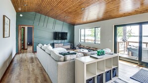 Una sala de estar moderna con techo de madera, un ventanal y vistas al exterior.
