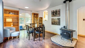 Ein gemütliches Wohnzimmer mit Kamin, Holzmöbeln und Blick ins Freie.