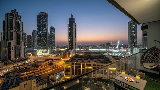 A high-rise building with a pool and dining area. - Delujo Stays – Burj Crown Collection (Dubai)