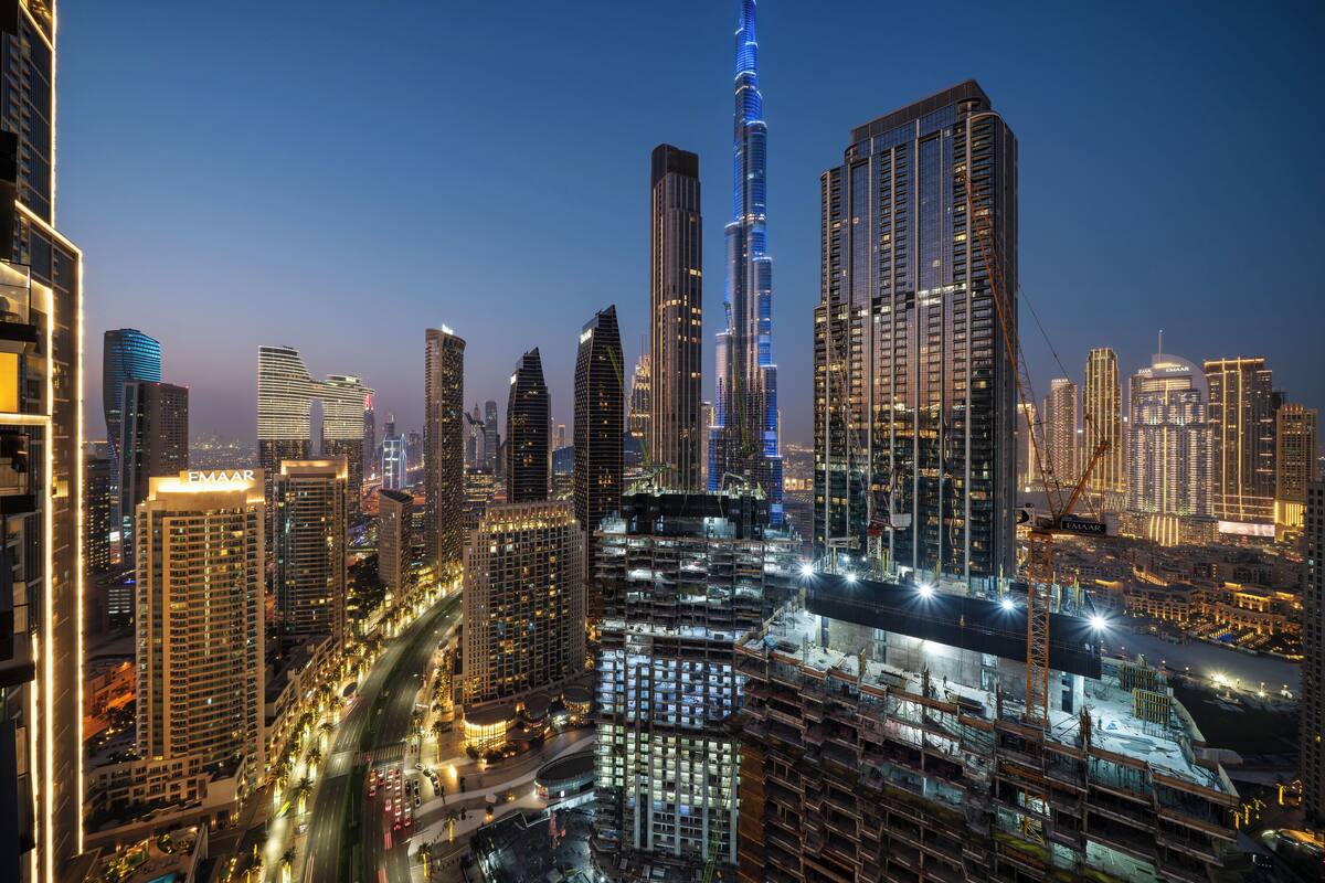 A cityscape with modern high-rise buildings, including a prominent tower with a unique design.