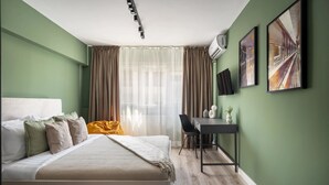 Ein Schlafzimmer mit einem Bett, einem Schreibtisch, einem Sessel und zwei Wandklimaanlagen.