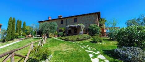 A rustic stone building with a garden path leading to the entrance.