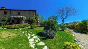 A stone building with a garden path leading to it. - Panoramic apartment with swimming pool and private garden (Firenze)