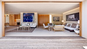 A modern living room with a large painting, a sofa, a coffee table, and a wooden floor. - Melides Premium Villa With Pool by Homing (Grandola)