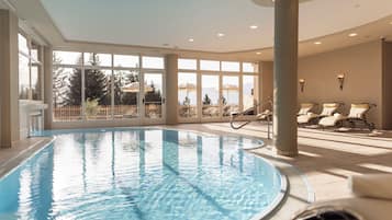 Alberca techada, alberca al aire libre y sombrillas en la alberca