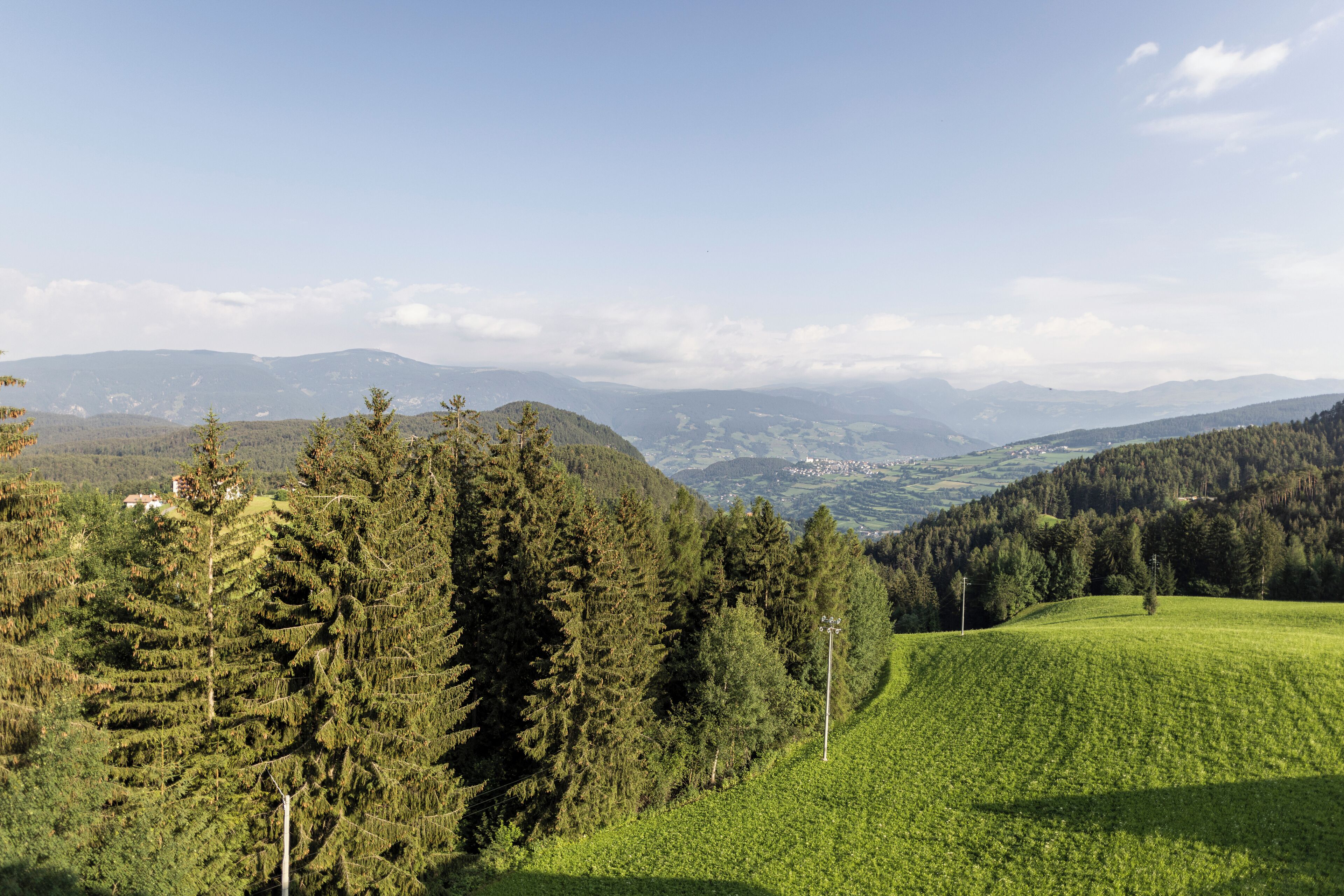Un paysage montagneux, avec de vastes forêts et des collines ondulantes.