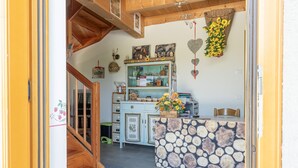 Une cuisine chaleureuse avec un escalier en bois, un mur en pierre qui en constitue l’élément central, et divers ustensiles de cuisine.