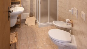 A bathroom with a shower, sink, toilet, and a wooden cabinet. - Agriturismo Filippon- Room Stalla (Tambre)