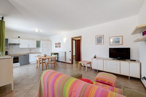 A modern apartment with a kitchen, dining area, and living room.