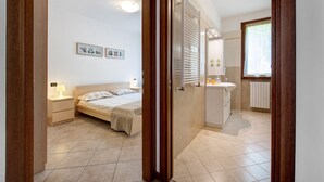 A bedroom with a bed, bedside table, and wall-mounted pictures.