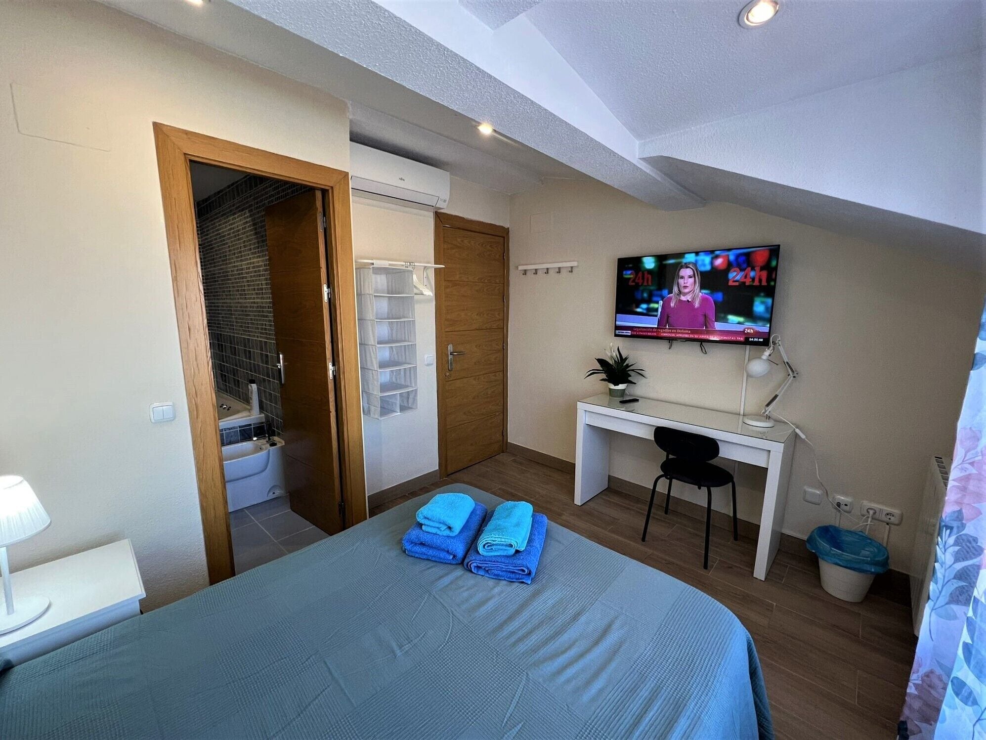 Une chambre d’hôtel avec un lit, un bureau, une télévision et une salle de bain.