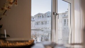 A view through a window of a building with a balcony and a railing. - Inselzeit Comfort Suite No. 7 (Sellin)