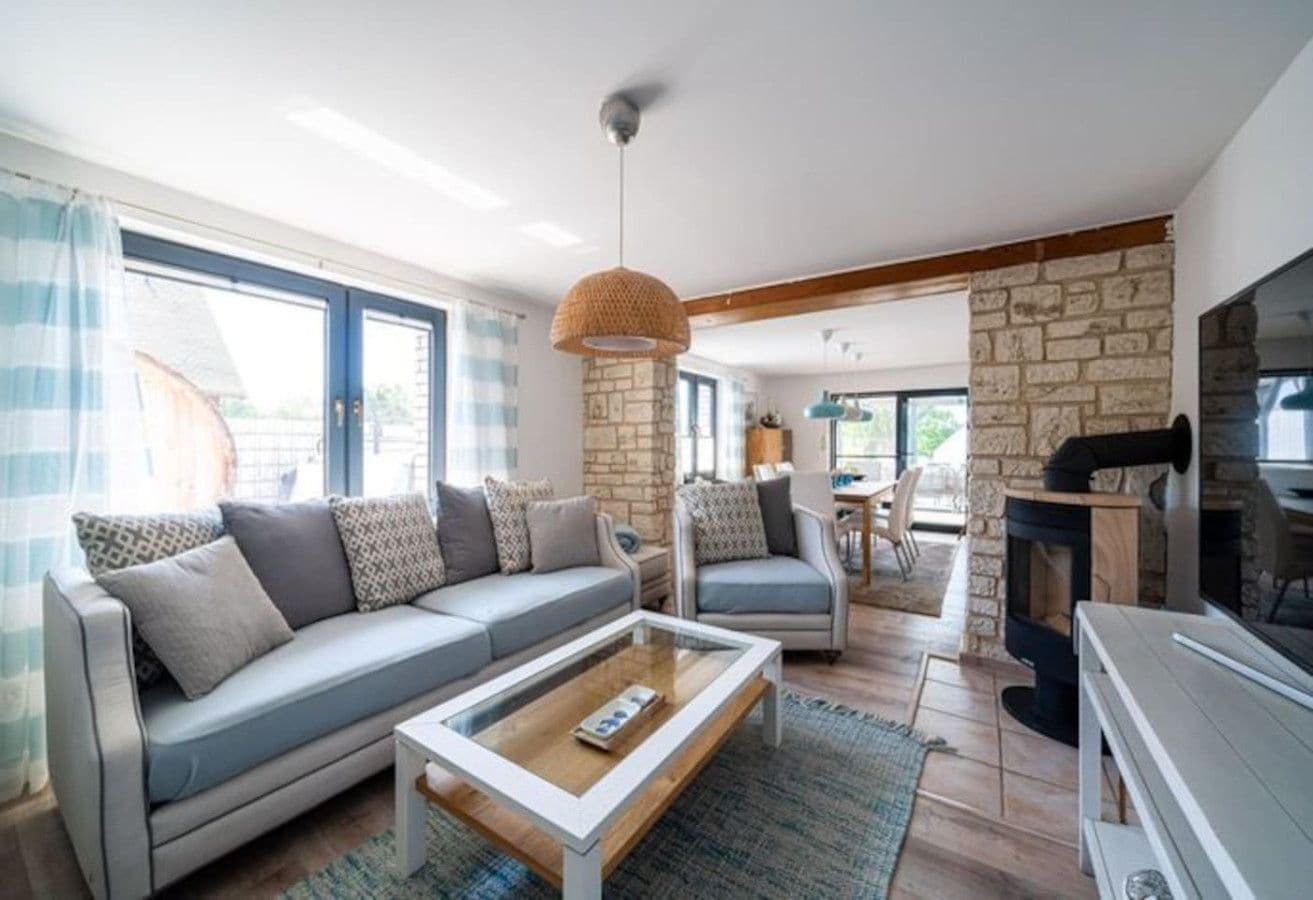 A modern living room with a sofa, coffee table, and fireplace.