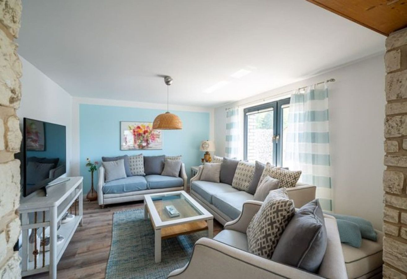 A living room with a sofa set, a coffee table, a TV, and a lamp.