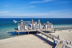 Un bâtiment situé sur la côte, doté d’une jetée qui s’avance dans la mer, avec de nombreuses fenêtres et une vue dégagée sur l’océan.