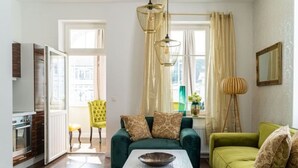 Un salon moderne avec un canapé vert, une table basse blanche et un fauteuil jaune.