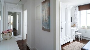 Una habitación con un aparador blanco, un cuadro y un espejo.