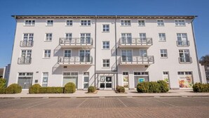 A multi-story building with a symmetrical facade, balconies, and a central entrance. - Inselzeit Comfort Suite No. 20 (Sellin)