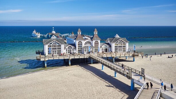A coastal building with a pier extending into the sea, featuring multiple windows and a clear view of the ocean. - Inselzeit Comfort Suite No. 20 (Sellin)