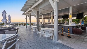 A covered outdoor seating area with tables and chairs, a bar, and umbrellas. - 7-min Walk to Beach | 6-Seater LSV (Santa Rosa Beach)