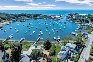 Vue aérienne d’une marina où sont amarrés de nombreux bateaux, entourée de bâtiments résidentiels et de verdure.